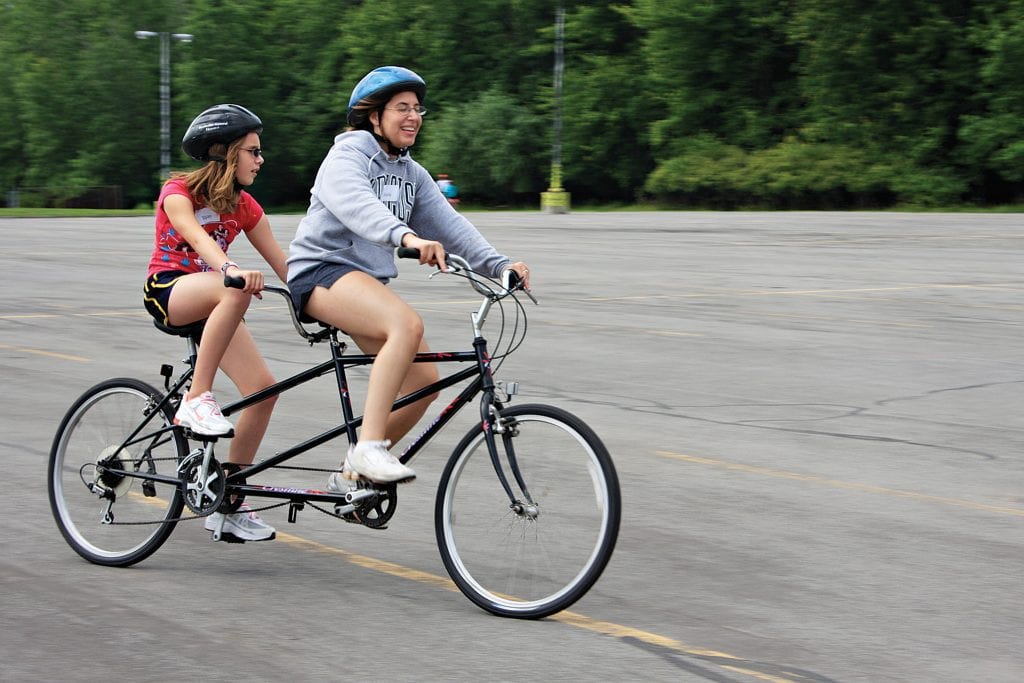 Two women riding a tandem bike