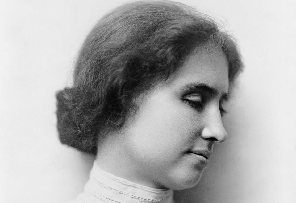 A black and white photo of Helen Keller with her head turned to the right
