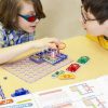 Two boys working on a circutry project using Snap Circuits Jr.