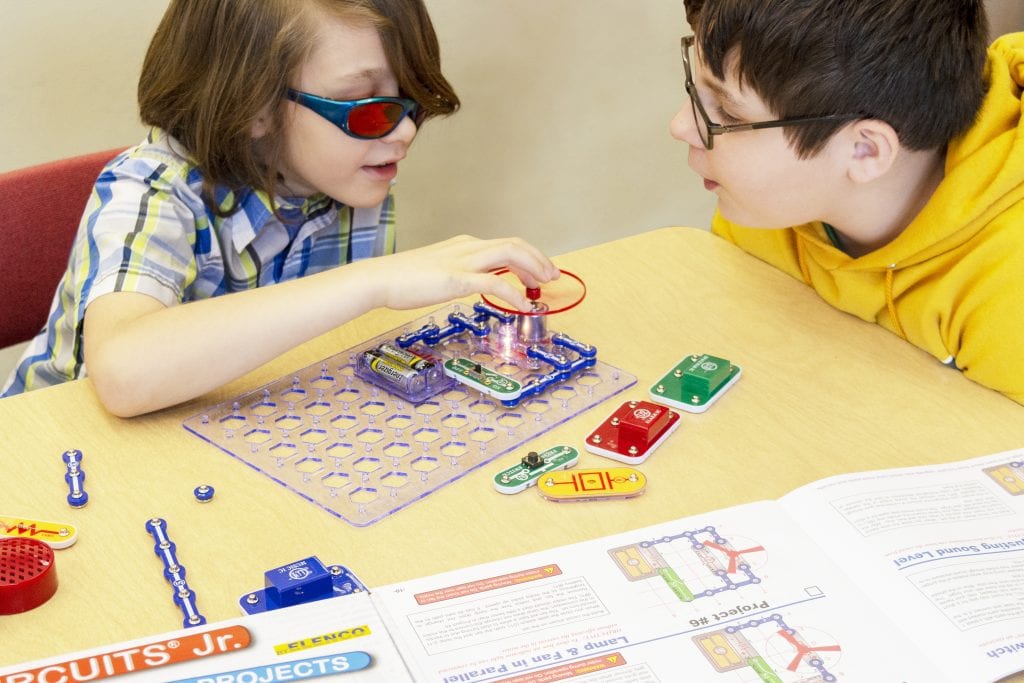 Two boys working on a circutry project using Snap Circuits Jr.