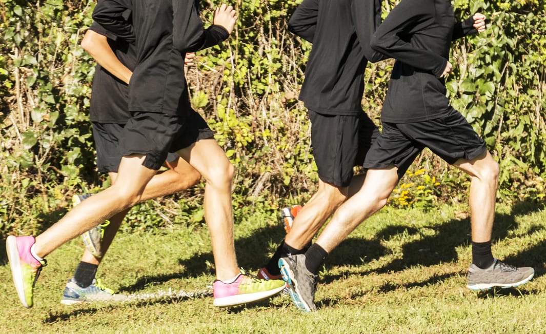 boys high school cross country team running in a group