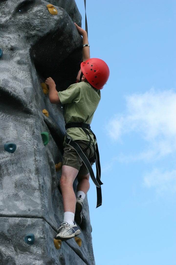 boy climbing on a training rock face