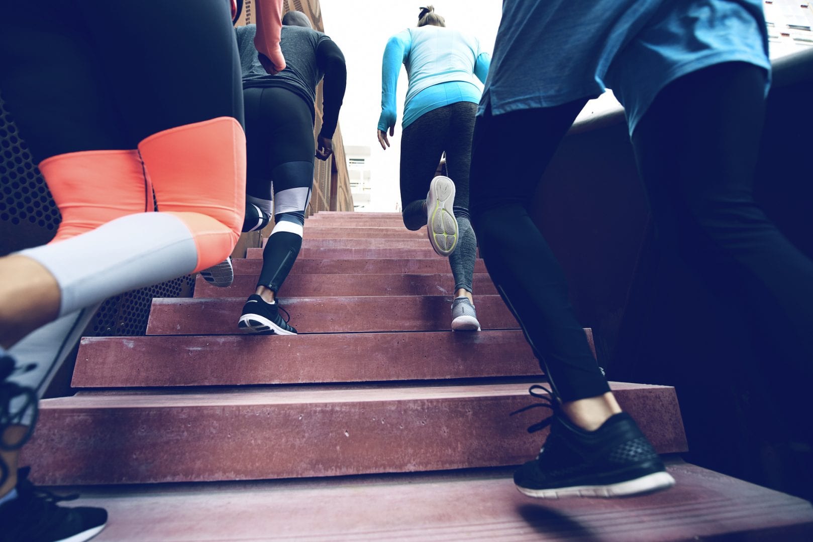 A small group of people running up the stairs