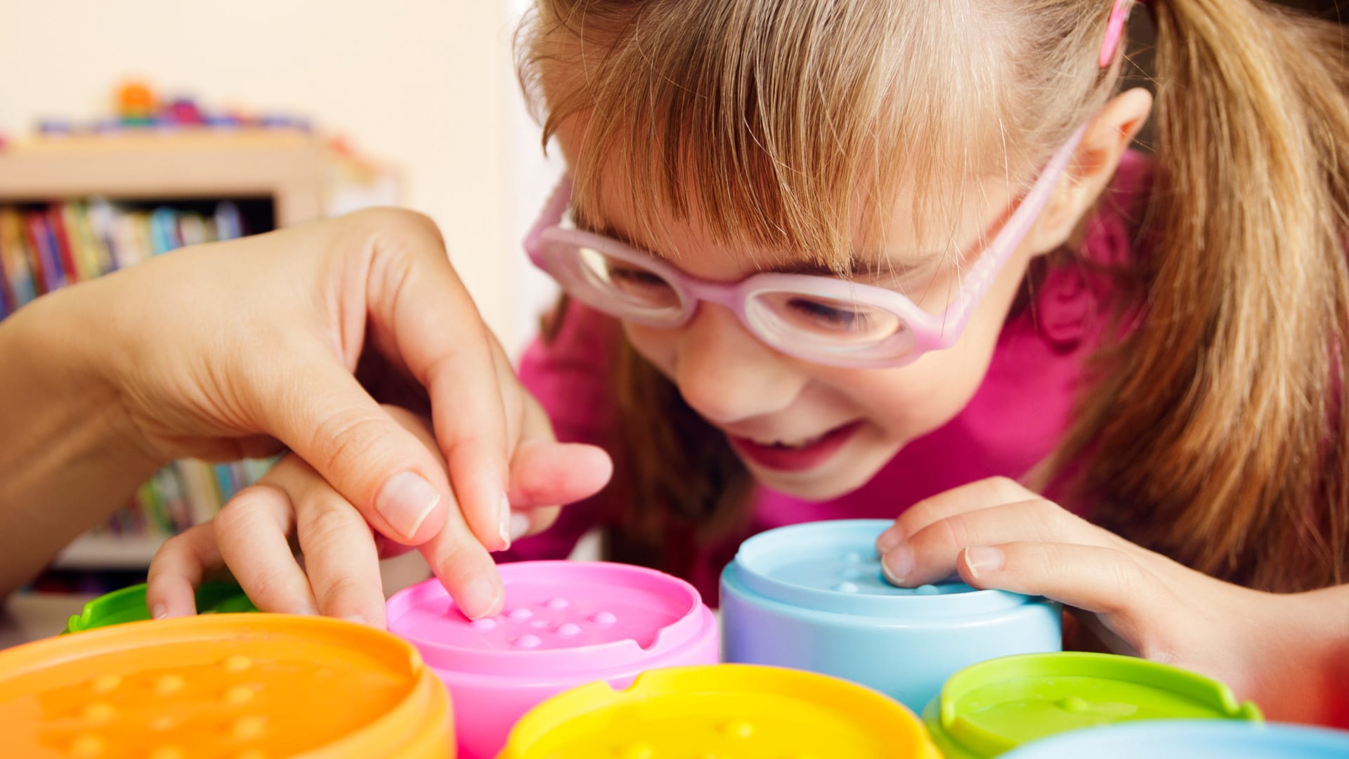 Young girl discovering textures on tactile toys