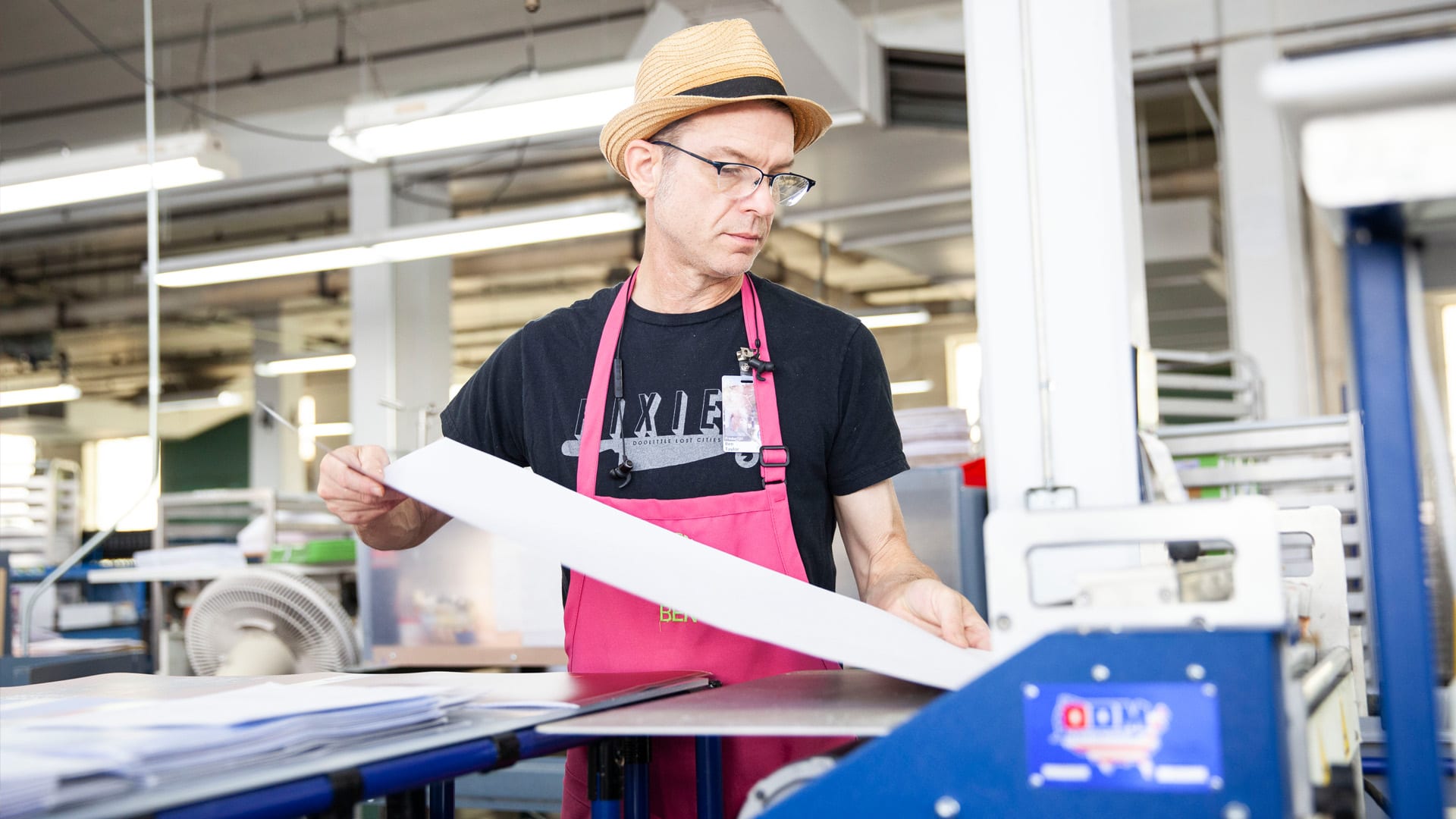 An APH employee running a printing machine