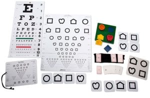 A variety of acuity measurement charts, symbol cards, and a puzzle board laid out on a white background.