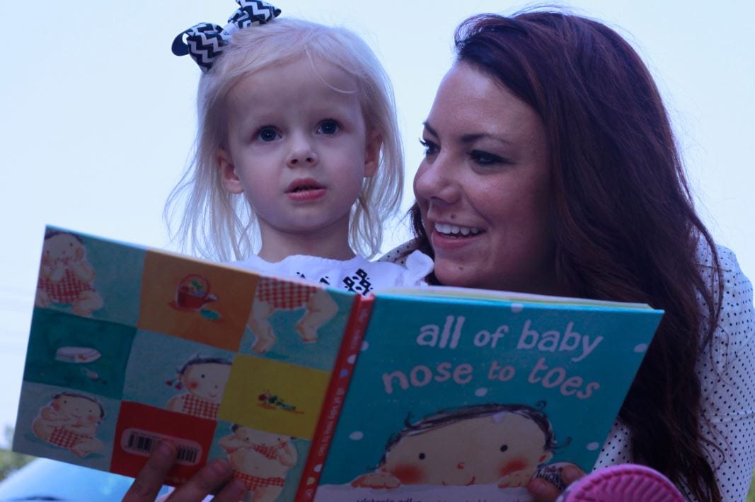 Woman reading children's book to a toddler