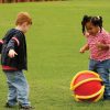 Young boy and girl playfully kicking a APH Rib-it Ball