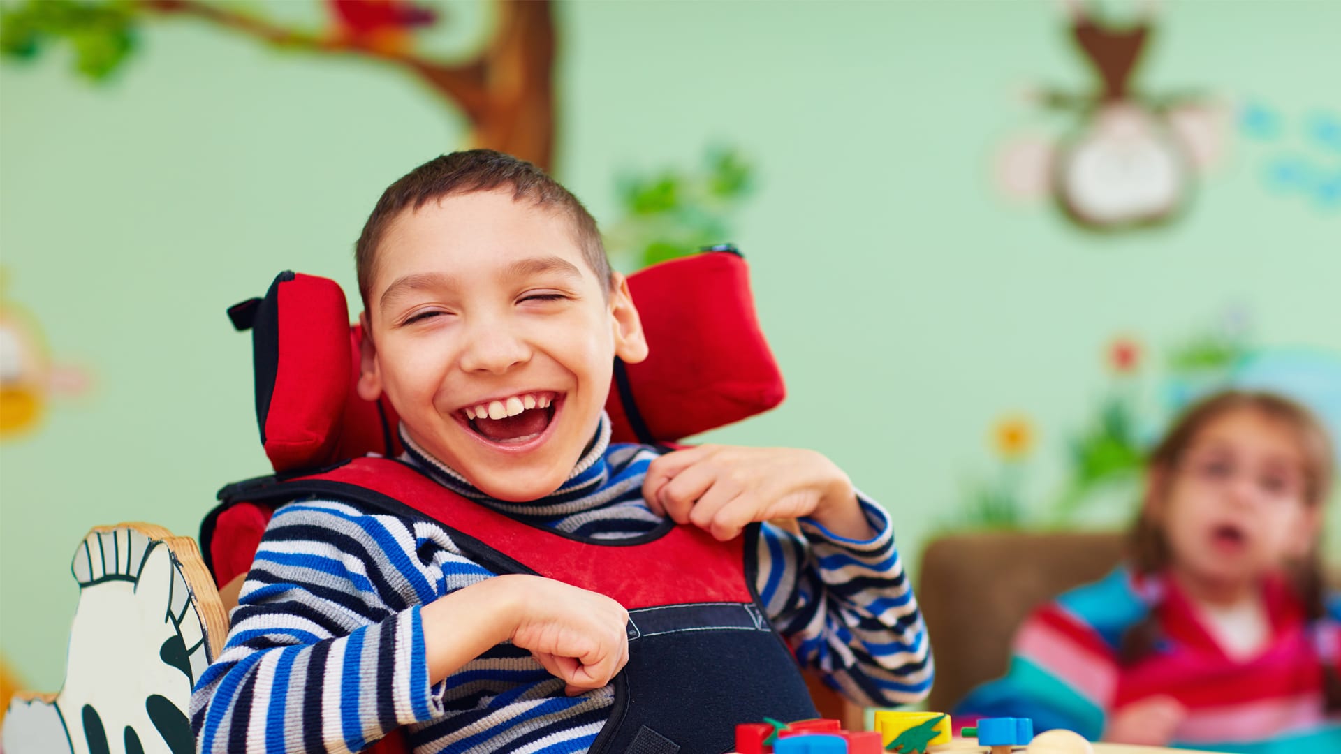 Young boy in a wheelchair laughing