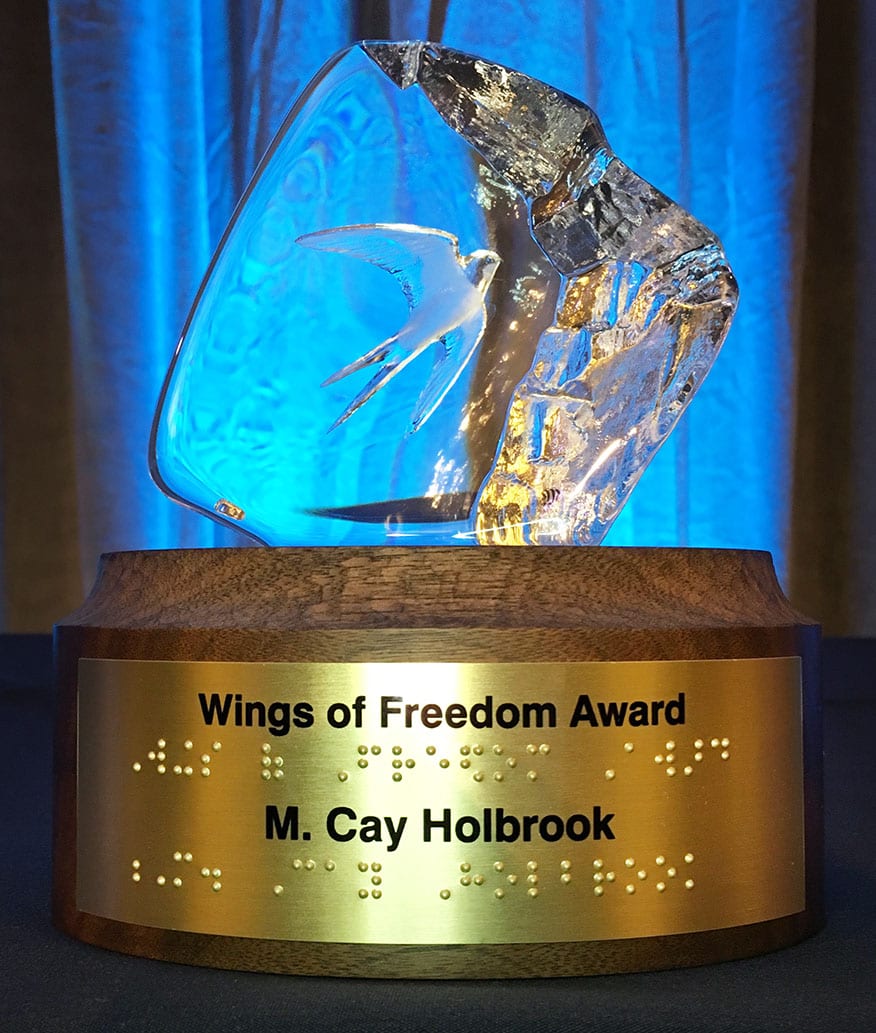 Wings of Freedom Award glass statue on wood base with print and braille label