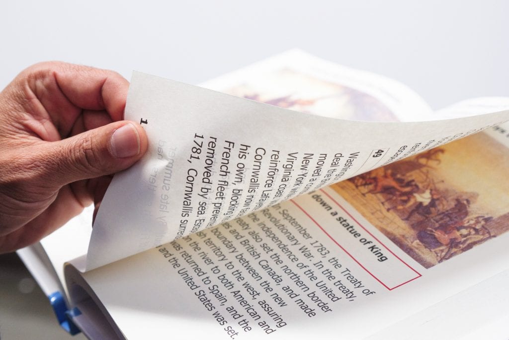 A hand turning a page of a book