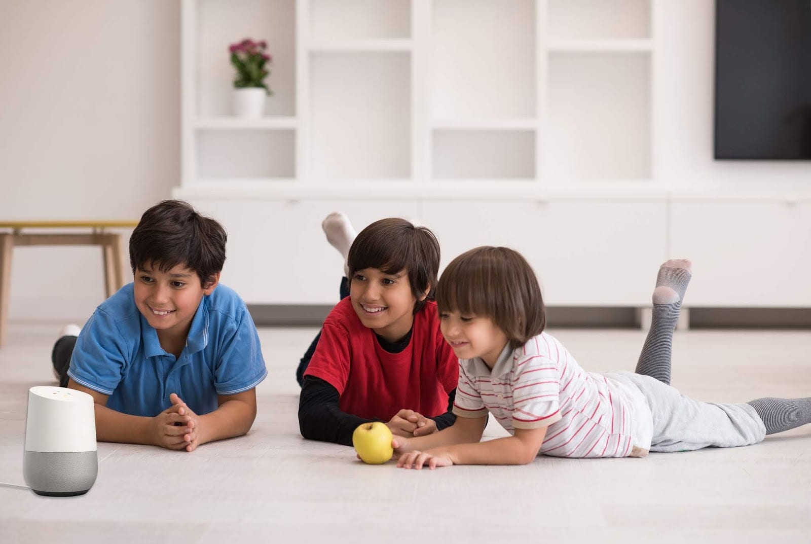 happy young boys having fun with a Google Home on the floor in a new modern home