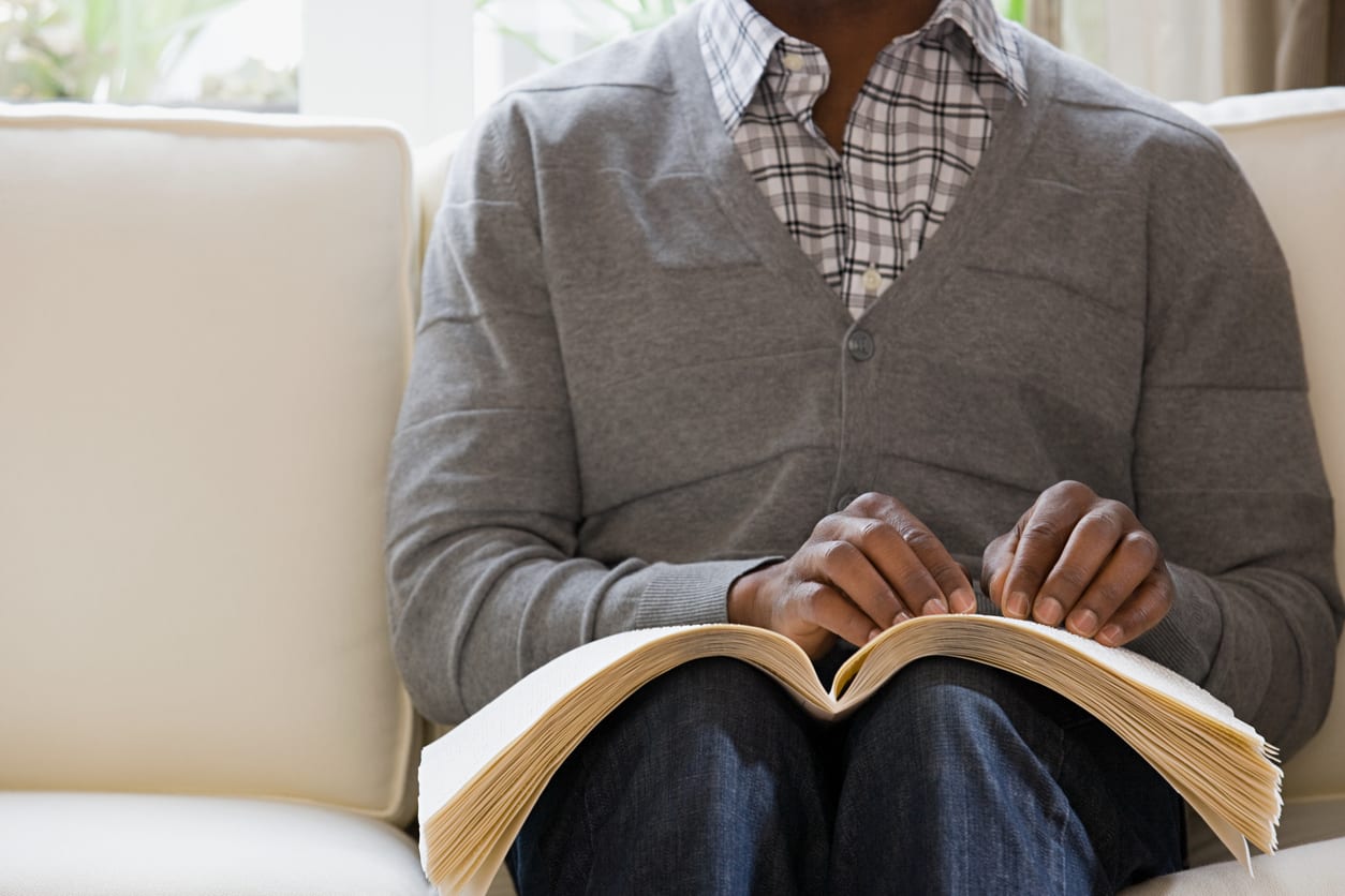 A man reading a braille book