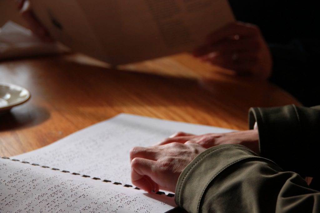 close up of hands on braille