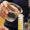 Student pouring water into an adapted graduated cylinder.