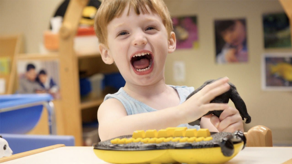 boy smiling with Braille Buzz