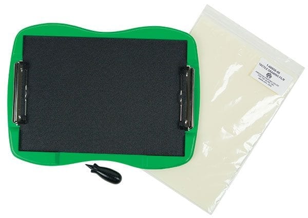 Components of the TactileDoodle kit against a white background including the curved green frame with the black padded surface, the black stylus, and a package of tactile drawing film
