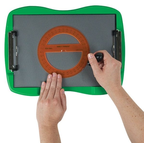 One hand holds an orange protractor in place on tactile drawing film attached to the green TactileDoodle frame. The other hand, holding the black stylus, is tracing the outside of the protractor
