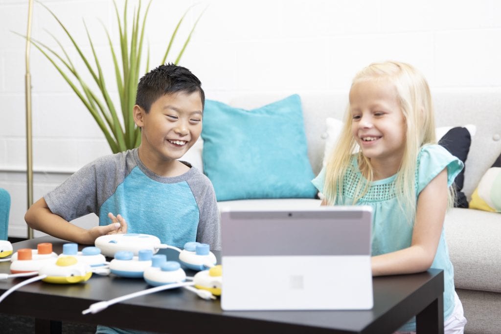 a boy and girl in a living room playing with Code Jumper