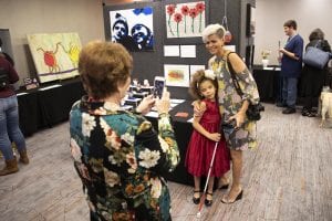 a young artsit and her mother having their picture taken at the InSights Art exhibition