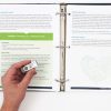 A hand holding the USB drive with the APH logo included in the Health Education Guidebook kit. In the background, the Health Education guidebook is open to two pages detailing instructions for an activity to simulate a lymphatic vessel.