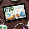 A tablet sitting on a table displaying the Code Jumper Puzzle – CJ Gets a Job! On the tablet’s screen is an image of CJ, a blue cat-like creature, wearing a chef's hat and making a pizza. Code Jumper pods lay on the table surrounding the tablet.