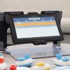 Code Jumper’s hub and colorful pods are connected to the MATT Connect with the Code Jumper app and a thread of code displayed on the tablet’s screen.