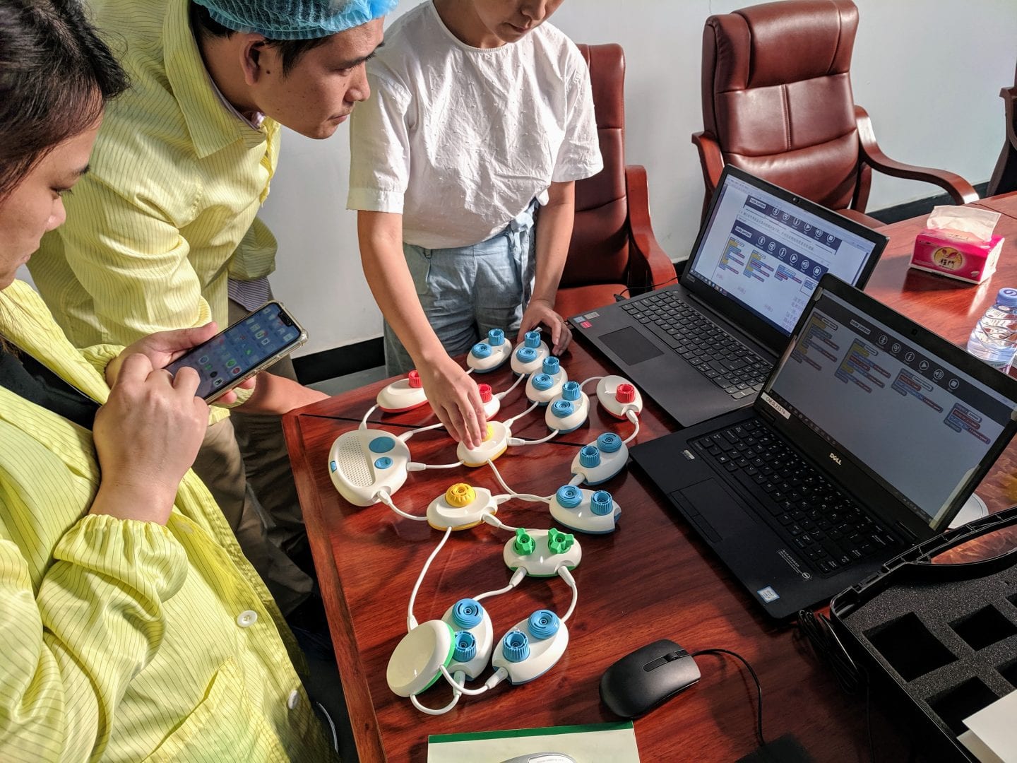 a group of people in lab coats testing code jumper on an office table