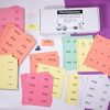 The box and full set of Wilson Reading System print-braille cards in a variety of colors laid out against a white and purple background.