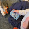 child holding a blue pop-a-cell block with braille on it