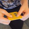 child holding a yellow pop-a-cell block with braille on it
