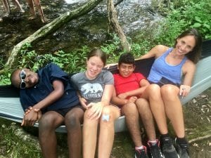 four camp Camp friends chill’n together in a hammock