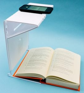 A smartphone with KNFB Reader on the portable stand above an open book