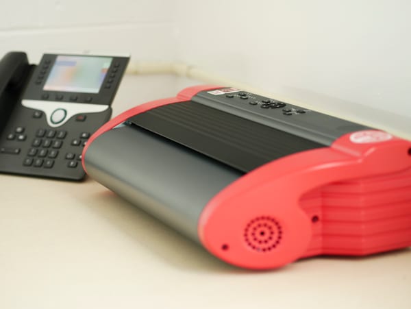 PageBlaster embosser on a desk next to an office phone