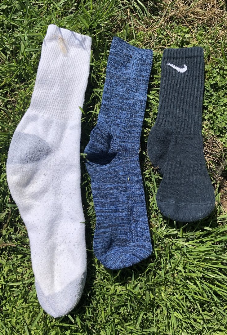 three different length socks laying in the grass from longest to shortest