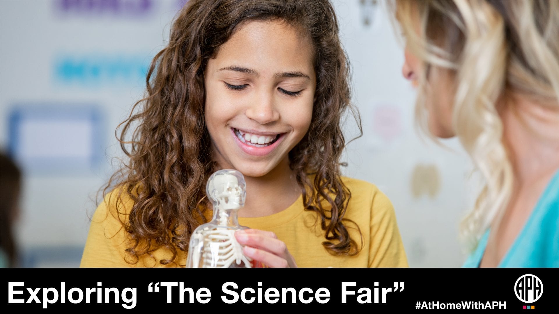 a girl holding a miniature model of the human skeleton and talking to an adult. text reads "Exploring 'The Science Fair' #AtHomeWithAPH"