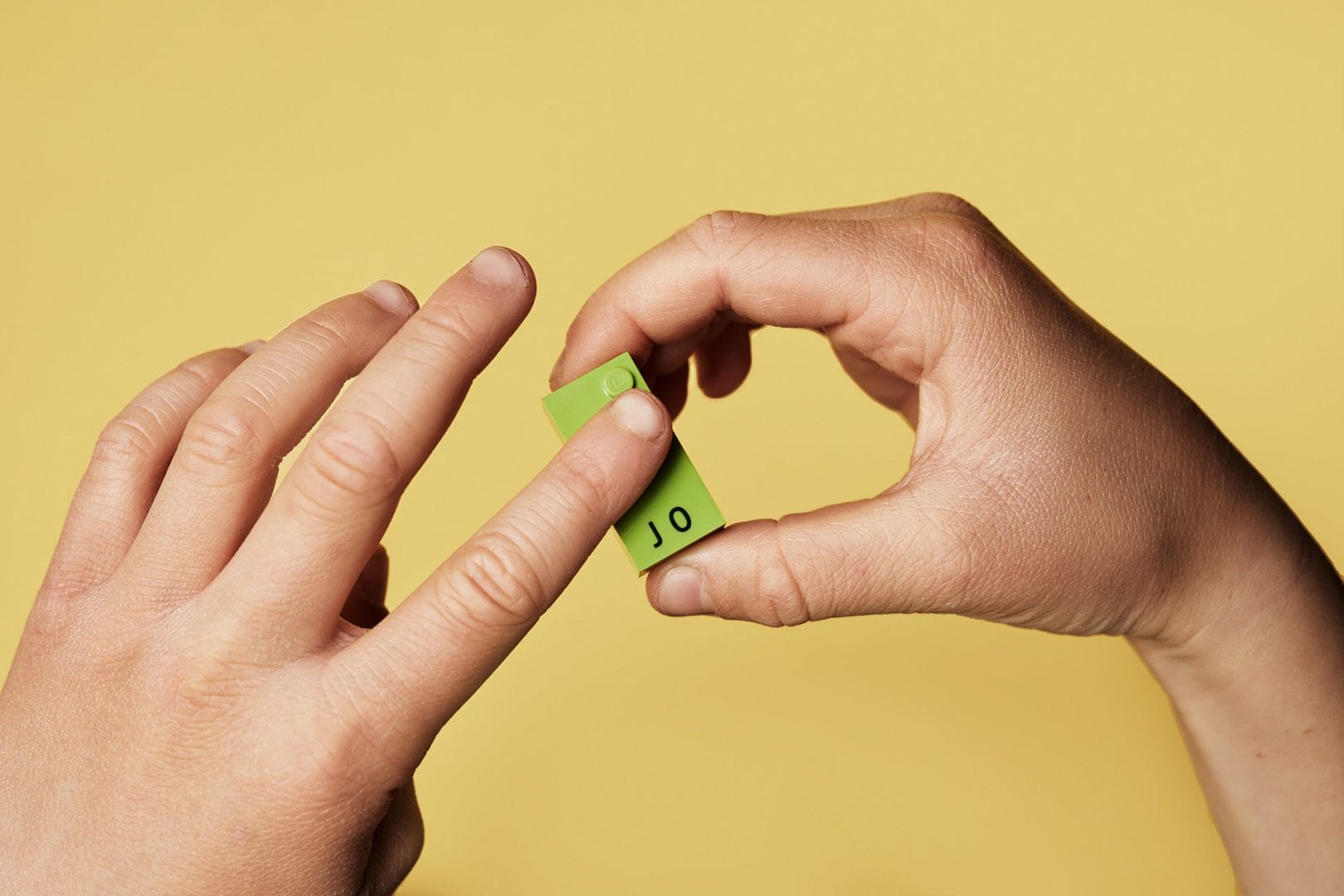 Child touching a LEGO Braille Brick