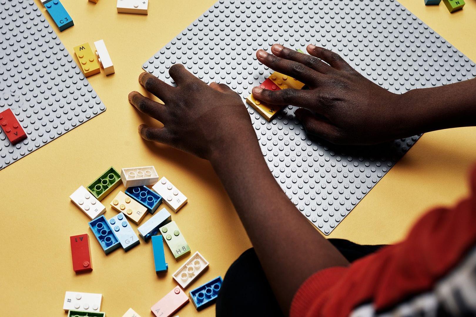 Close-up of child's hands learning through play with LEGO Braille Bricks