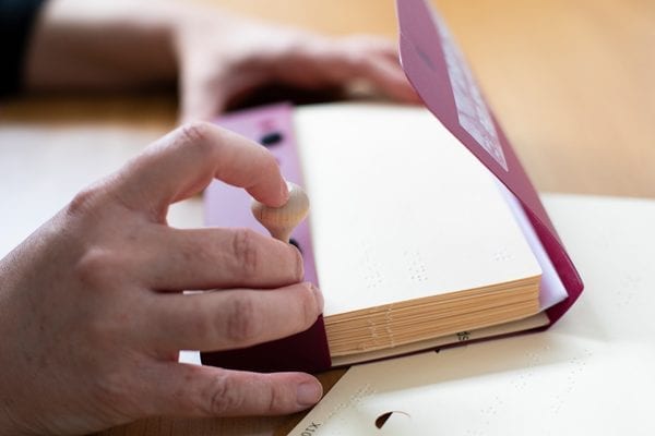 Sideview of two hands using Quick Pick Cards with case and picker