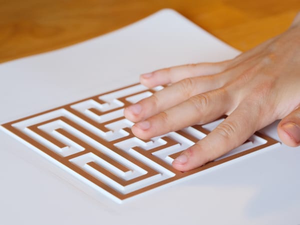 A hand tracing a Finger Walks tactile labyrinth.