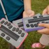 Students holding chameleon 20 braille displays