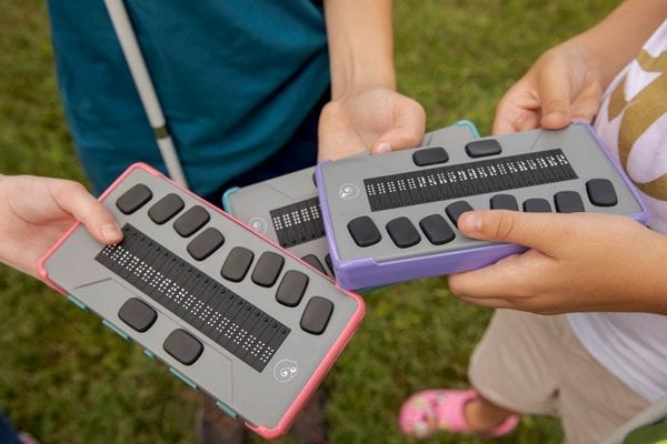 Students holding chameleon 20 braille displays