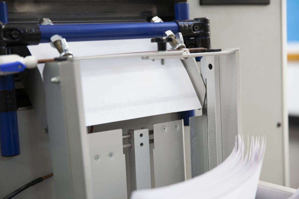 close up of printer and braille paper on the factory floor at APH