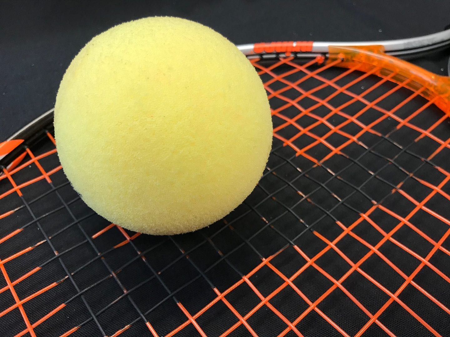 an aph tennis ball on a racket