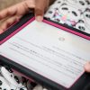 an iPad displaying the AnimalWatch Vi Graphics app is held in a person's lap