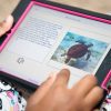 an iPad displaying the AnimalWatch Vi Graphics app is held in a person's lap