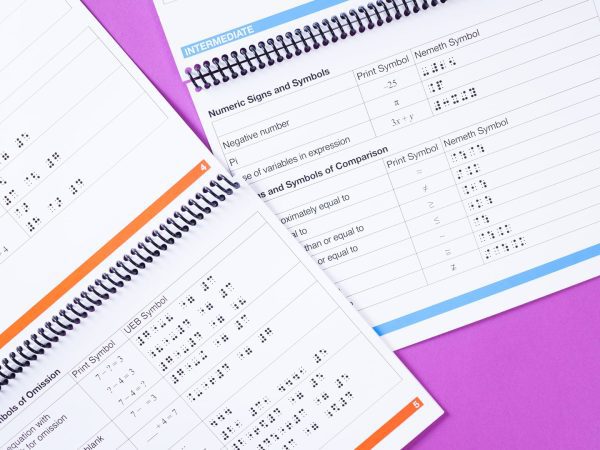 Math Symbols Reference Booklet internal pages with symbols featuring both print and either Nemeth or UEB symbols on spiral notebook