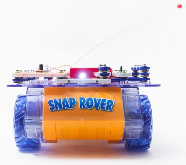 Front view of RC Snap rover, a bread board covered in snap circuits pieces sitting on a frame with wheels.