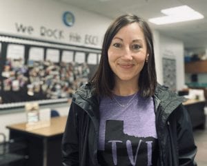 stacey smiling and standing in her colorfully decorated classroom