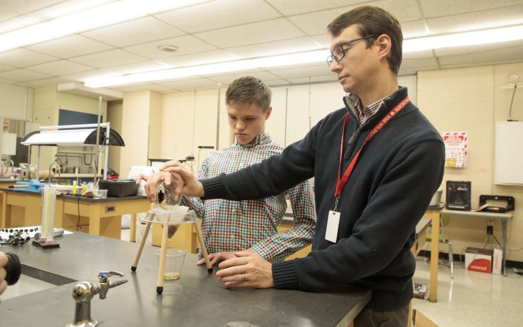 A student and teacher in a science lab using the Adapted Science Materials Kit.